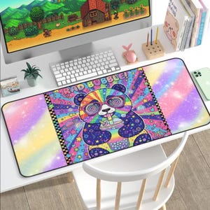 May include: A vibrant, rectangular mousepad featuring a colorful panda bear wearing rainbow-tinted glasses and drinking a bubble tea. The mousepad has the text "RAD BUBBLE!" and a psychedelic design with stars, planets, and swirls.