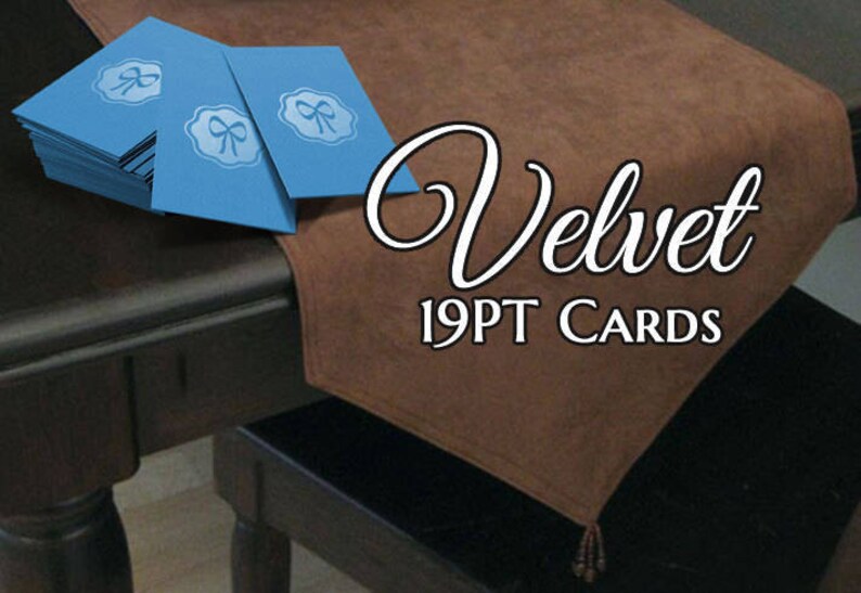 K&ouml;nnte beinhalten: Ein Stapel blauer Samtkarten mit einem Schleifendesign und dem Text "Velvet 19PT Cards" auf einer braunen Samtoberfl&auml;che.