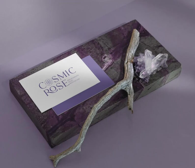 May include: A rectangular purple stone slab featuring a white business card with the text COSMIC ROSE, a weathered grey wooden twig, and a cluster of clear quartz crystals. The card also displays smaller text reading BREATHWORK REIKI MEDITATION.