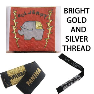 May include: A rectangular red woven label featuring a gray elephant icon, gold laurel branches, and the text SOLJERRY. Two black fabric labels are also shown, one with gold metallic thread and the text PANINA, and another with silver thread.