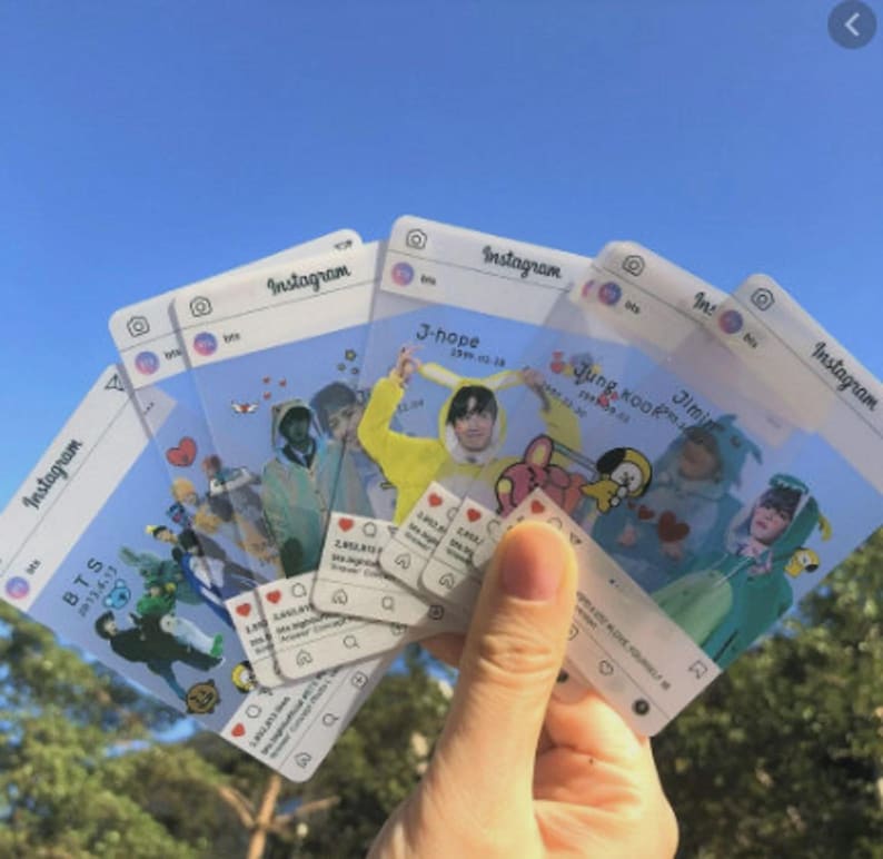 Puede incluir: Un conjunto de tarjetas de pl&aacute;stico transparente dise&ntilde;adas para parecer publicaciones de Instagram, con varios miembros del grupo musical BTS. Cada tarjeta muestra un encabezado de perfil, una imagen central y una interfaz de red social.