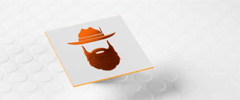 May include: A square white card featuring a metallic orange graphic of a wide-brimmed hat positioned above a thick, full beard. The card has a thin orange edge, and the design is centered on the flat surface of the white card stock.