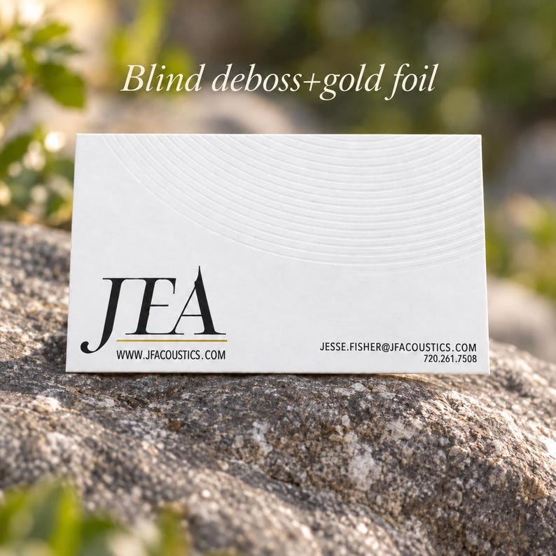 Puede incluir: Una tarjeta de visita rectangular blanca con el texto negro JEA, el sitio web www.jfacoustics.com, el correo jesse.fisher@jfacoustics.com y el n&uacute;mero 720.261.7508. La tarjeta tiene un patr&oacute;n de relieve ciego y detalles en pan de oro.
