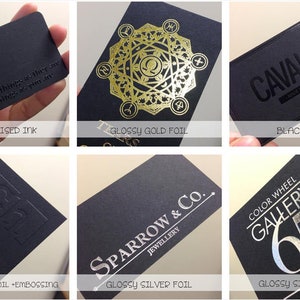 May include: A collection of six rectangular black business cards showcasing various printing techniques including black raised ink, glossy gold foil, black foil, glossy silver foil with embossing, and standard glossy silver foil with custom text.