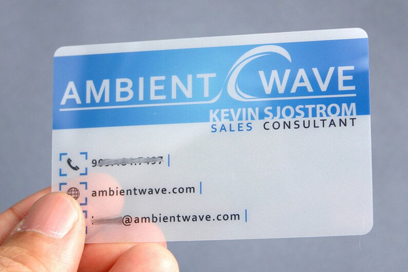 May include: A rectangular, semi-transparent business card featuring a blue gradient header with the white text AMBIENT WAVE. Below, the name KEVIN SJOSTROM and SALES CONSULTANT are printed, followed by contact icons for phone, website, and email.