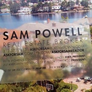 Może przedstawiać: Prostokątna, przezroczysta wizyt&oacute;wka z czarnym tekstem zawierającym napis SAM POWELL, REAL ESTATE BROKER, dane kontaktowe oraz tytuły zawodowe, w tym 2016 Women's Council of Realtors Illinois State President i 2014 Chicago President.