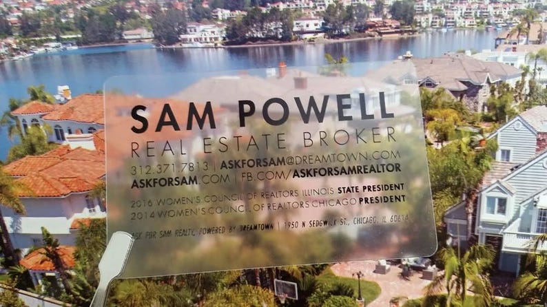 Może przedstawiać: Prostokątna, przezroczysta wizyt&oacute;wka z czarnym tekstem zawierającym napis SAM POWELL, REAL ESTATE BROKER, dane kontaktowe oraz tytuły zawodowe, w tym 2016 Women's Council of Realtors Illinois State President i 2014 Chicago President.