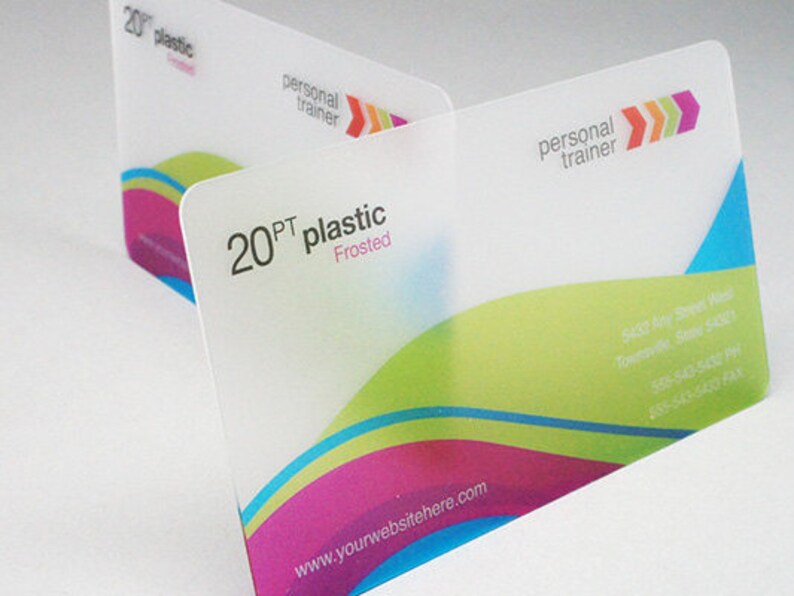 May include: Two rectangular 20PT frosted plastic business cards featuring a personal trainer logo with three colored arrows. The design includes wavy bands of lime green, magenta, and cyan, with printed contact information and a website address.