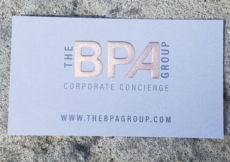 May include: A light blue business card with the text "THE BPA GROUP CORPORATE CONCIERGE" in a rose gold color. The website address www.thebpagroup.com is printed at the bottom in gray.