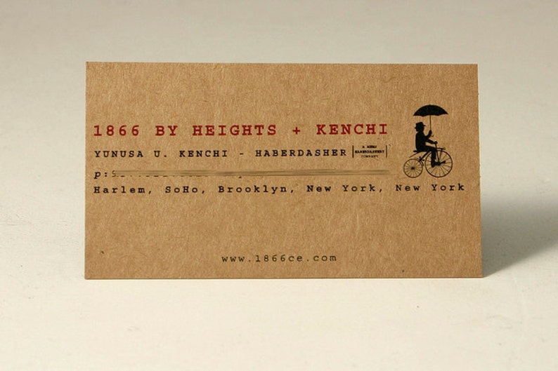May include: A rectangular tan business card with black and red text. It reads 1866 BY HEIGHTS + KENCHI, YUNUSA U. KENCHI - HABERDASHER, and lists locations including Harlem, SoHo, Brooklyn, New York. A black silhouette of a person on a bicycle with an umbrella is present.