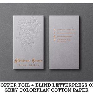 May include: Two rectangular grey business cards featuring copper foil text and blind letterpress floral designs. The front displays the text Blossom House Floral Design, while the back lists contact details including phone, email, and website.