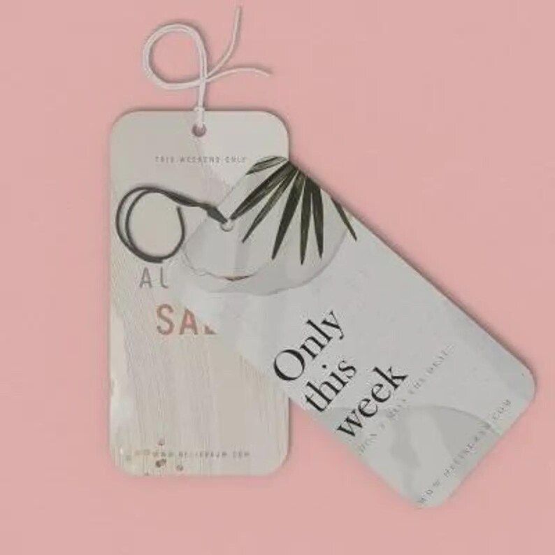 May include: Two rectangular paper tags with rounded corners and white string loops. The top tag features a palm leaf graphic and the black text "Only this week". The bottom tag displays the text "AL" and "SALE" in a light pink font.