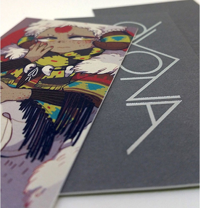 May include: A stack of cards featuring an illustration of a person with a red dot on their forehead, wearing a colorful patterned jacket and white fur trim. The card on the right has the word "ZONA" in silver lettering.