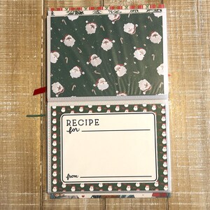 Puede incluir: Libro de recetas navide&ntilde;as abierto con un fondo verde con motivos de Pap&aacute; Noel y bastones de caramelo. La p&aacute;gina de recetas tiene un fondo blanco con las palabras "RECIPE for:" y "from:" impresas en negro.