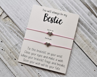 May include: A white card with pink string bracelets attached. The card reads "You will always be my Bestie."  One for me. One for you. Tie this bracelet on your wrist. Close your eyes and make a wish. When your bracelet frays and breaks, soon your wish will be your fate.