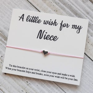 May include: A white card with the text "A little wish for my Niece" and a pink string bracelet with a small silver heart charm. The card includes instructions for making a wish.
