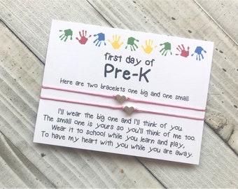 May include: A card with the text "first day of Pre-K" and a message about two bracelets, one big and one small. The card says "I'll wear the big one and I'll think of you. The small one is yours so you'll think of me too. Wear it to school while you learn and play, To have my heart with you while you are away."