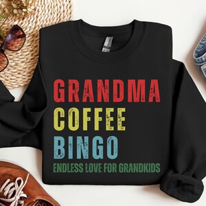 May include: Black sweatshirt with the text "Grandma Coffee Bingo Endless Love for Grandkids" in colorful vintage-style lettering.