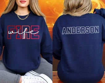 May include: Navy blue sweatshirt with the word "FIRE" in red block letters and "wife" in white script. The back of the sweatshirt displays the name "ANDERSON" in white block letters.