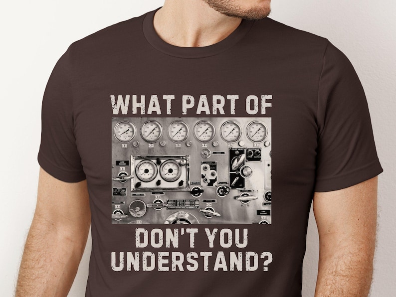 May include: A brown t-shirt with a graphic of a control panel with gauges and the text "WHAT PART OF DON'T YOU UNDERSTAND?"