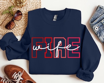 May include: Navy blue sweatshirt with the text "FIRE wife" in red and white lettering.