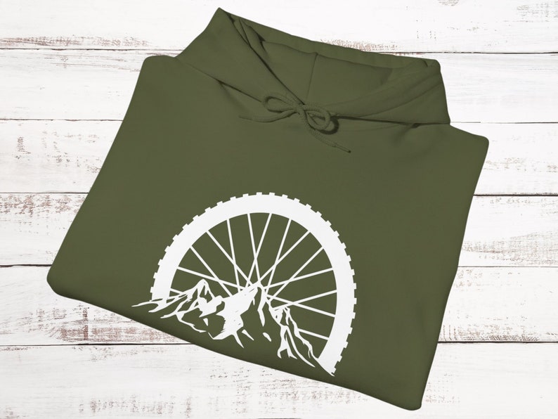 May include: A green hooded sweatshirt with a white mountain silhouette and bicycle wheel design.
