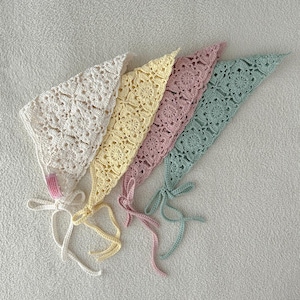 May include: Four handmade crochet bonnets in pastel colors: ivory, yellow, pink, and mint green. Each bonnet features a floral pattern and ties with matching ribbons. These bonnets are ideal for babies and young children.