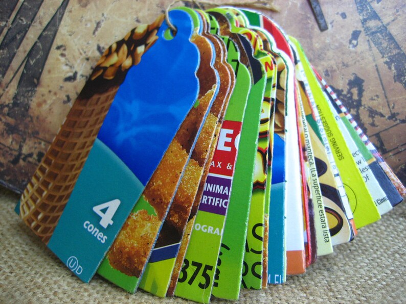 Puede incluir: Una pila de etiquetas de productos coloridas con varias im&aacute;genes y texto. La etiqueta superior es azul y presenta una imagen de un cono de helado con el texto "4 cones".
