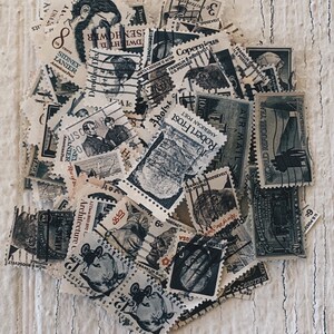 Puede incluir: Una colección de sellos postales antiguos con diversos diseños, incluyendo retratos, paisajes y figuras históricas. Los sellos son de varios colores y tamaños, y algunos han sido cancelados con tinta.