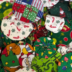 May include: A collection of colorful, round Christmas ornaments. The ornaments feature various festive patterns, including gift boxes, candy canes, snowflakes, and Santa Claus. The color palette includes red, green, white, and blue.