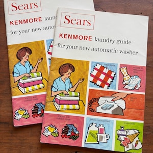 May include: Two vintage Sears Kenmore laundry guides. The covers feature illustrations of a woman sorting laundry and colorful diagrams. The guides are titled "KENMORE laundry guide for your new automatic washer."
