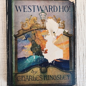May include: A vintage hardback book titled "Westward Ho!" by Charles Kingsley. The cover features an illustration of a ship sailing on the ocean with a sunset in the background.