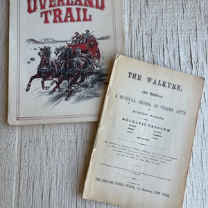 May include: Two vintage playbills, one for the musical drama "The Walkyre" by Richard Wagner and the other for the play "Overland Trail". The Walkyre playbill features a black and white illustration of a horse-drawn carriage. The Overland Trail playbill features a colorful illustration of a stagecoach being pulled by four horses.