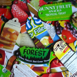 Puede incluir: Primer plano de varias etiquetas de embalaje de alimentos de colores. Las etiquetas muestran im&aacute;genes de fruta, panqueques y una escena de bosque. El texto en las etiquetas incluye "Organic Bunny Fruit Snacks Tropical Treat", "Forest Where Nature's Best Comes From", "Complete Pancake Mix" y "Nutrition Facts".
