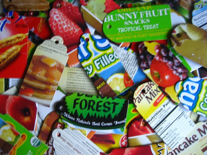 Puede incluir: Primer plano de varias etiquetas de embalaje de alimentos de colores. Las etiquetas muestran im&aacute;genes de fruta, panqueques y una escena de bosque. El texto en las etiquetas incluye "Organic Bunny Fruit Snacks Tropical Treat", "Forest Where Nature's Best Comes From", "Complete Pancake Mix" y "Nutrition Facts".