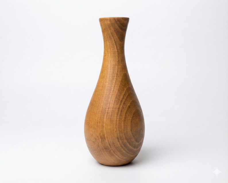 Puede incluir: Un jarr&oacute;n de madera artesanal con forma de l&aacute;grima. El jarr&oacute;n est&aacute; hecho de madera de color marr&oacute;n claro y tiene un acabado liso y pulido. El jarr&oacute;n mide aproximadamente 25 cm de altura.