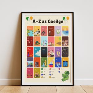 May include: A framed poster featuring the alphabet in the Irish language, "A-Z as Gaeilge", with colourful illustrations. The poster is in a black frame and is displayed on a wooden floor against a white wall.
