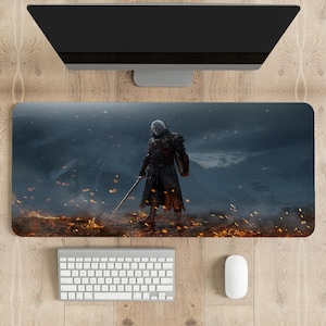 May include: A large, dark grey gaming mouse mat featuring a fantasy character standing in a fiery landscape. The character is wearing dark armour and holding a sword. The background is a dark, stormy sky.