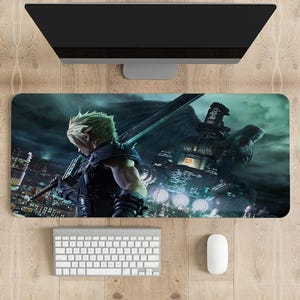May include: A rectangular gaming mouse mat featuring a character with a large sword, set against a futuristic cityscape. The design is predominantly dark with shades of blue and green. A white keyboard and mouse are below a computer monitor.
