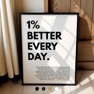 以下が含まれることがあります： 黒いフレームに入ったプリントで、大きな黒い文字で「1% BETTER EVERY DAY」と書かれています。プリントには、メインテキストの下に小さなフォントでモチベーションメッセージが含まれています。フレームは長方形で、背景は白です。