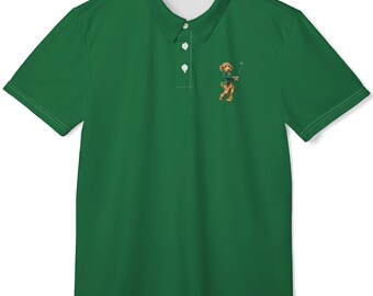 May include: A solid dark green short-sleeve polo shirt with a classic collar and a three-button placket. On the left chest, there is a small embroidered graphic of a brown dog wearing a green sweater and holding a golf club in its mouth.