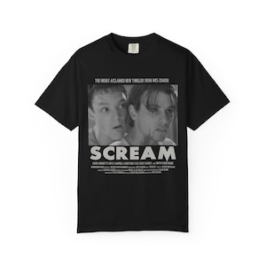 Pu&ograve; includere: T-shirt nero con grafica in bianco e nero del film "Scream". Il design include il titolo del film e il testo "THE HIGHLY ACCLAIMED NEW THRILLER FROM WES CRAVEN". La maglietta &egrave; un classico girocollo.