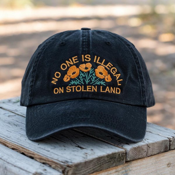 Gorra negra bordada con flores «Nadie es ilegal» – Justicia Social