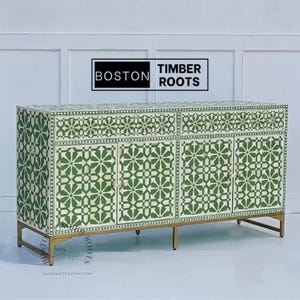 May include: A green and white bone inlay sideboard with three doors and two drawers. The sideboard has a geometric pattern and gold metal legs. The text "BOSTON TIMBER ROOTS" is visible on the top of the sideboard.