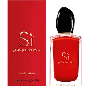 May include: A red Giorgio Armani Sì Passione perfume bottle and box. The bottle has a black cap and gold accents. The box and bottle both feature the words "Sì Passione" in gold script. The bottle contains 3.4 fl oz of perfume.
