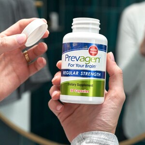 May include: A white bottle of "Prevagen For Your Brain" dietary supplement, held in hands. The bottle has a blue and white label with the words "Regular Strength" and "60 Capsules". The lid is being removed.
