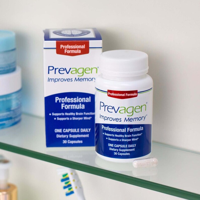 May include: A white bottle and box of Prevagen dietary supplements. The bottle and box have blue and red accents and the text "Prevagen Improves Memory". The box and bottle state "Professional Formula" and "One Capsule Daily". A single capsule is visible.