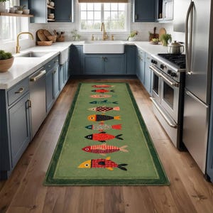 May include: A long rectangular runner rug featuring a sage green background with a central vertical row of nine stylized fish. Each fish displays a unique pattern, including stripes, dots, and solid colors in shades of red, orange, and blue.