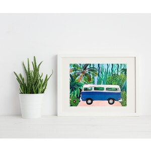 May include: A framed art print featuring a blue and white vintage van parked on a pink road, set against a backdrop of lush green tropical foliage. The artwork is in a white frame, evoking a sense of travel and adventure.