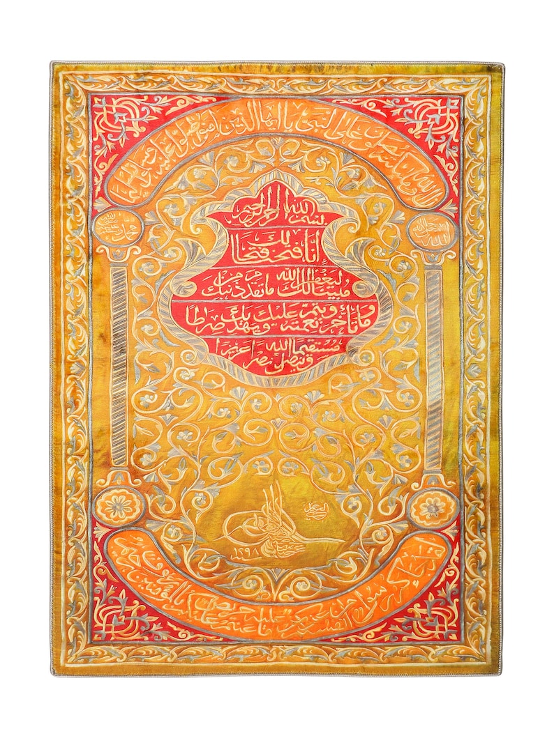 Pu&ograve; includere: Un pannello rettangolare ricamato con sfondo dorato e accenti rossi e argentati. Il pannello presenta intricati disegni floreali e calligrafia araba. Il testo recita "ولي الله ما تقد ذنبك ) مانا و نعمته عليك ويهدمر بالمطا مستقيما الله العزيز قنصل مصر".